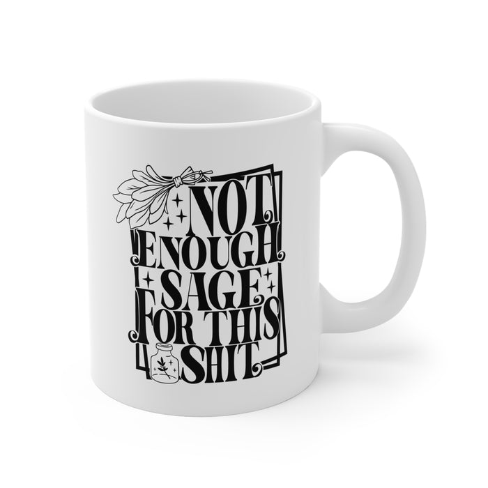 White ceramic mug featuring bold black typography reading “Not Enough Sage For This Shit,” framed in a whimsical outlined border. The design includes a detailed sage bundle illustration at the top and a small jar with a sage leaf motif at the bottom, adding a witchy, mystical vibe. Perfect for humorous coffee or tea moments, it blends sassy attitude with boho and spiritual flair, making it an ideal gift for friends with a sense of humor.