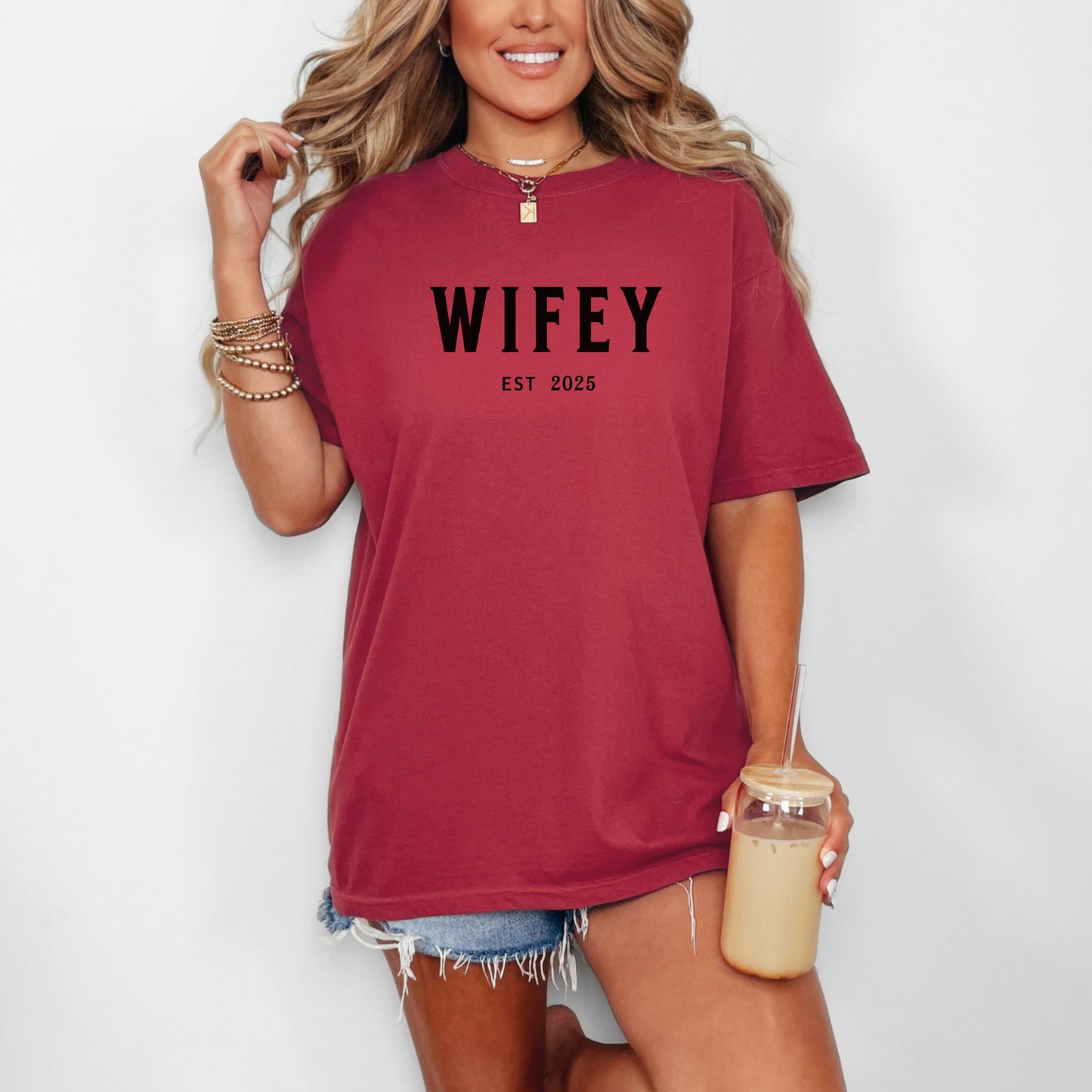 Chili T-shirt with the text "WIFEY EST 2025" in bold black lettering, celebrating a newlywed or engaged status. The modern minimalist design makes it perfect for brides, honeymoon outfits, or casual newlywed style. Ideal for wedding gifts, bridal showers, or anniversary celebrations.
