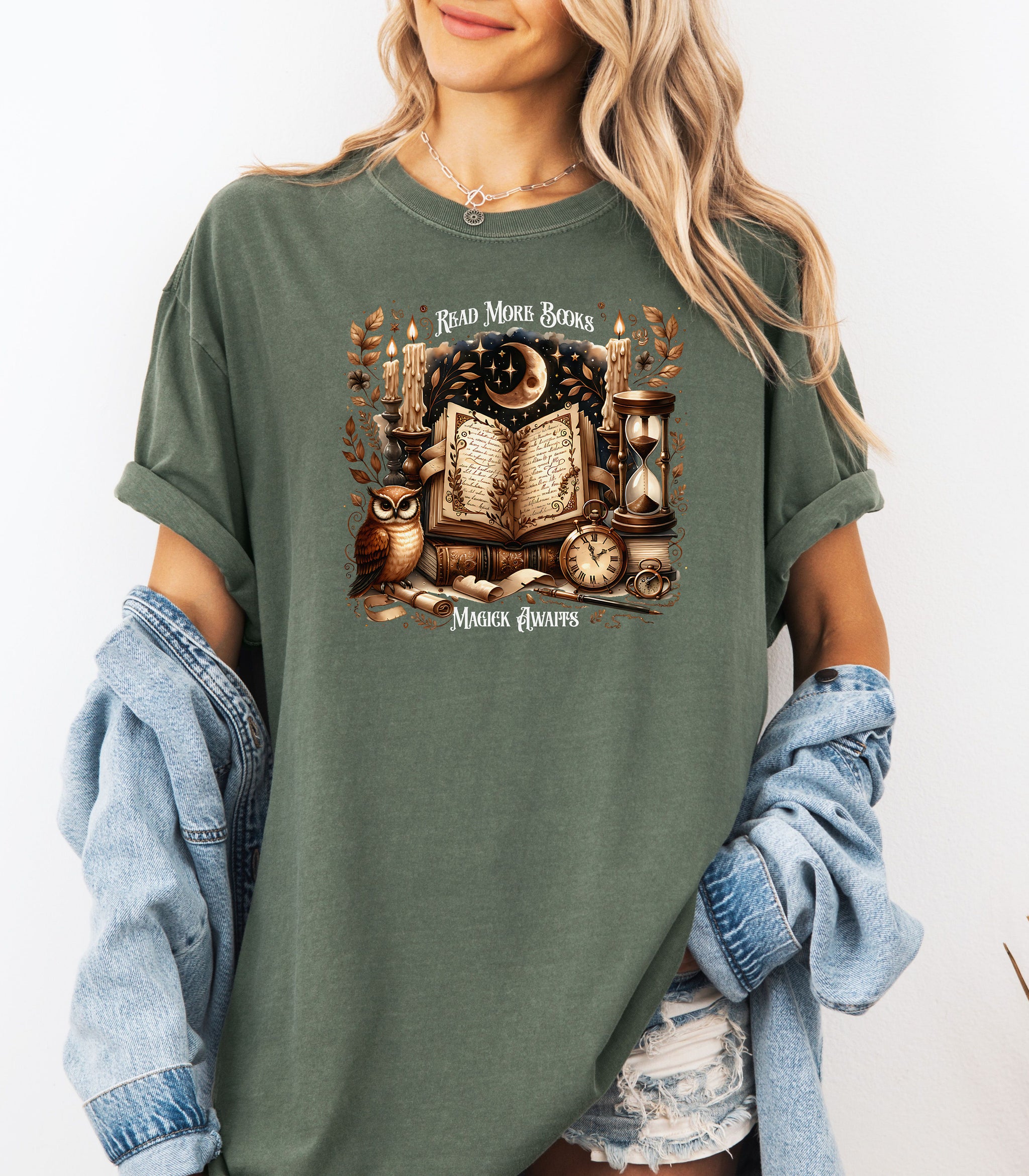 Person wearing a Hemp color t-shirt featuring a whimsical "Read More Books, Magick Awaits" design. The graphic showcases an open enchanted book surrounded by candles, a crescent moon, owl, pocket watch, hourglass, and magical elements, creating a mystical and literary aesthetic perfect for book lovers and fantasy fans.