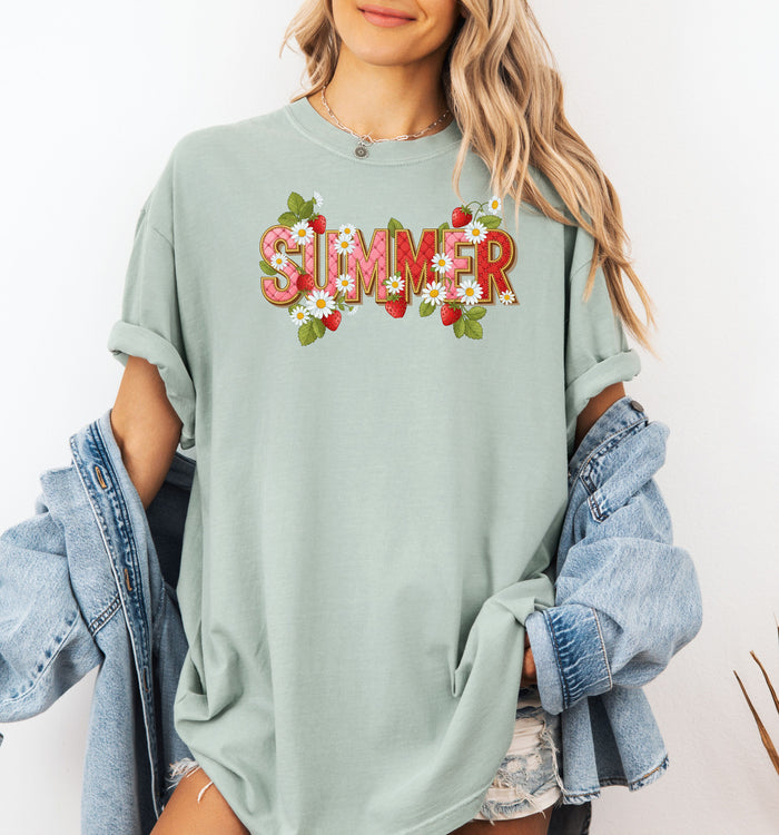 Bay T-shirt featuring a vibrant “SUMMER” graphic decorated with red strawberries, green leaves, and white daisies. The fresh, playful design captures a bright and cheerful summer vibe, perfect for casual warm-weather outfits.