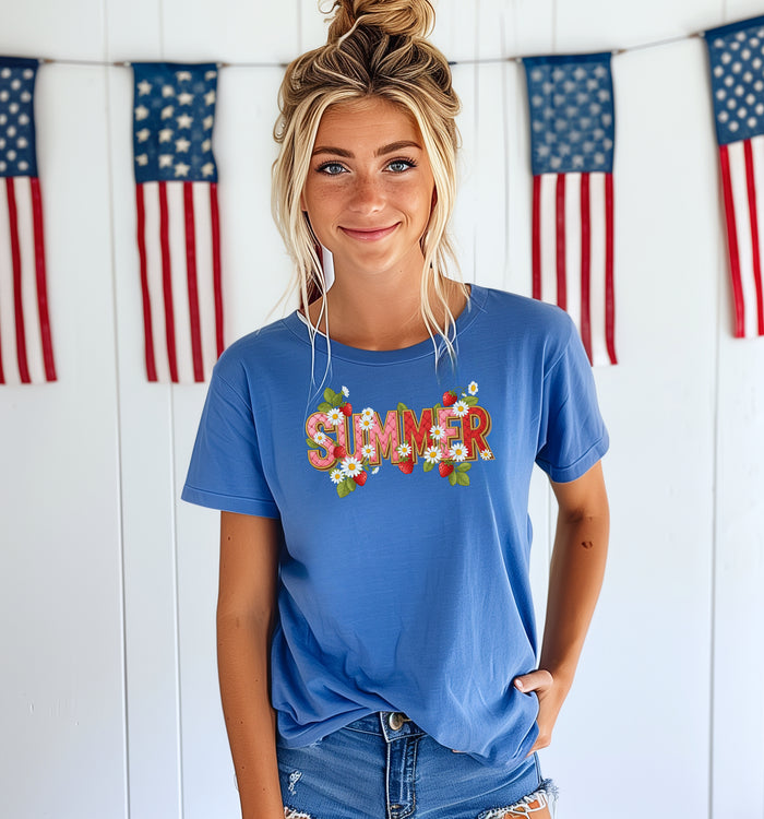 Flo Blue T-shirt featuring a vibrant “SUMMER” graphic decorated with red strawberries, green leaves, and white daisies. The fresh, playful design captures a bright and cheerful summer vibe, perfect for casual warm-weather outfits.