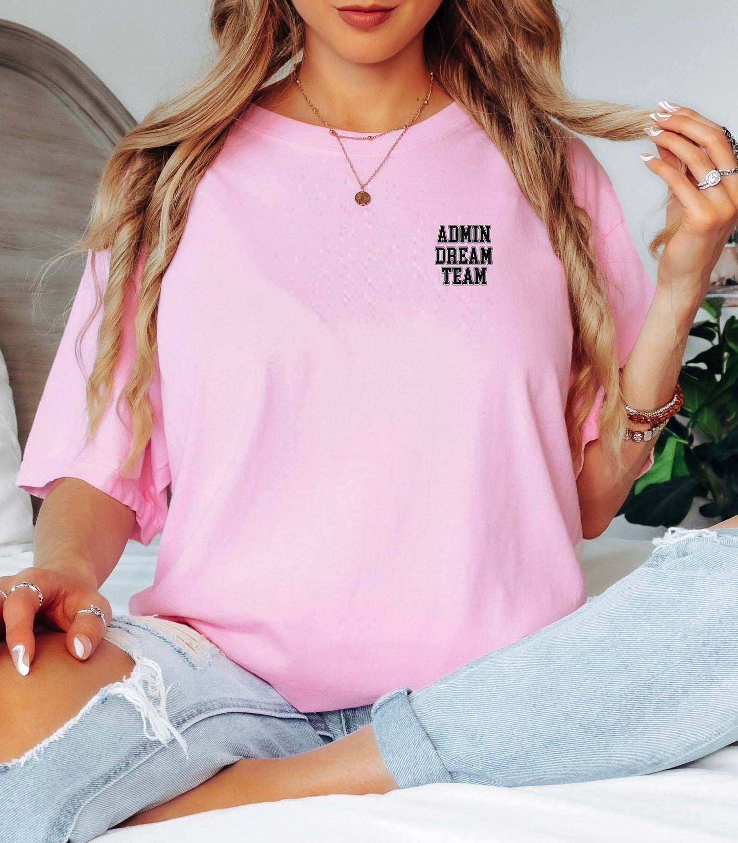 Person wearing a Blossom pink t-shirt, featuring a minimalist white text design on the left chest that reads "ADMIN DREAM TEAM." Perfect for school staff, office teams, or administrative professionals showing team spirit in a stylish and understated way.