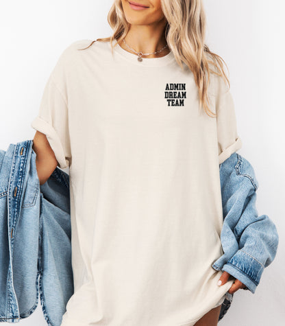 Person wearing an Ivory t-shirt, featuring a minimalist white text design on the left chest that reads "ADMIN DREAM TEAM." Perfect for school staff, office teams, or administrative professionals showing team spirit in a stylish and understated way.