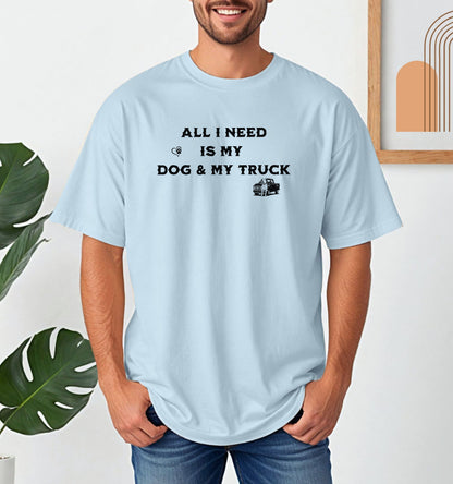 All I Need is My Dog & My Truck T-shirt featuring bold black text with small graphic icons of a paw print heart and a pickup truck. Printed on a chambray light blue unisex tee, this casual design is perfect for dog lovers and truck enthusiasts who embrace a laid-back, country lifestyle. Ideal for everyday wear, gifting, or showing off two favorite passions—dogs and trucks.