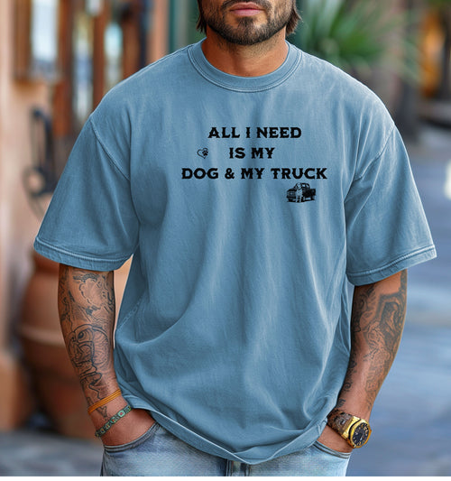 All I Need is My Dog & My Truck T-shirt featuring bold black text with small graphic icons of a paw print heart and a pickup truck. Printed on a washed denim unisex tee, this casual design is perfect for dog lovers and truck enthusiasts who embrace a laid-back, country lifestyle. Ideal for everyday wear, gifting, or showing off two favorite passions—dogs and trucks.