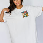 White t-shirt featuring a patriotic pocket design with an American flag waving over a scenic farmland landscape at sunset. The design includes the text 'USA EST 1776,' symbolizing pride and heritage. Perfect for 4th of July, country living, and casual patriotic style with a subtle, classic look.