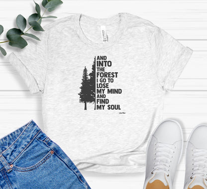 And Into The Forest I Go To Lose My Mind And Find My Soul T-shirt featuring a minimalist nature-inspired design with a tall pine tree alongside bold text of the famous John Muir quote. Printed on a soft ash unisex tee, this design celebrates mindfulness, outdoor adventure, and the healing power of nature. Perfect for hikers, campers, and forest lovers who find peace and clarity in the wilderness.