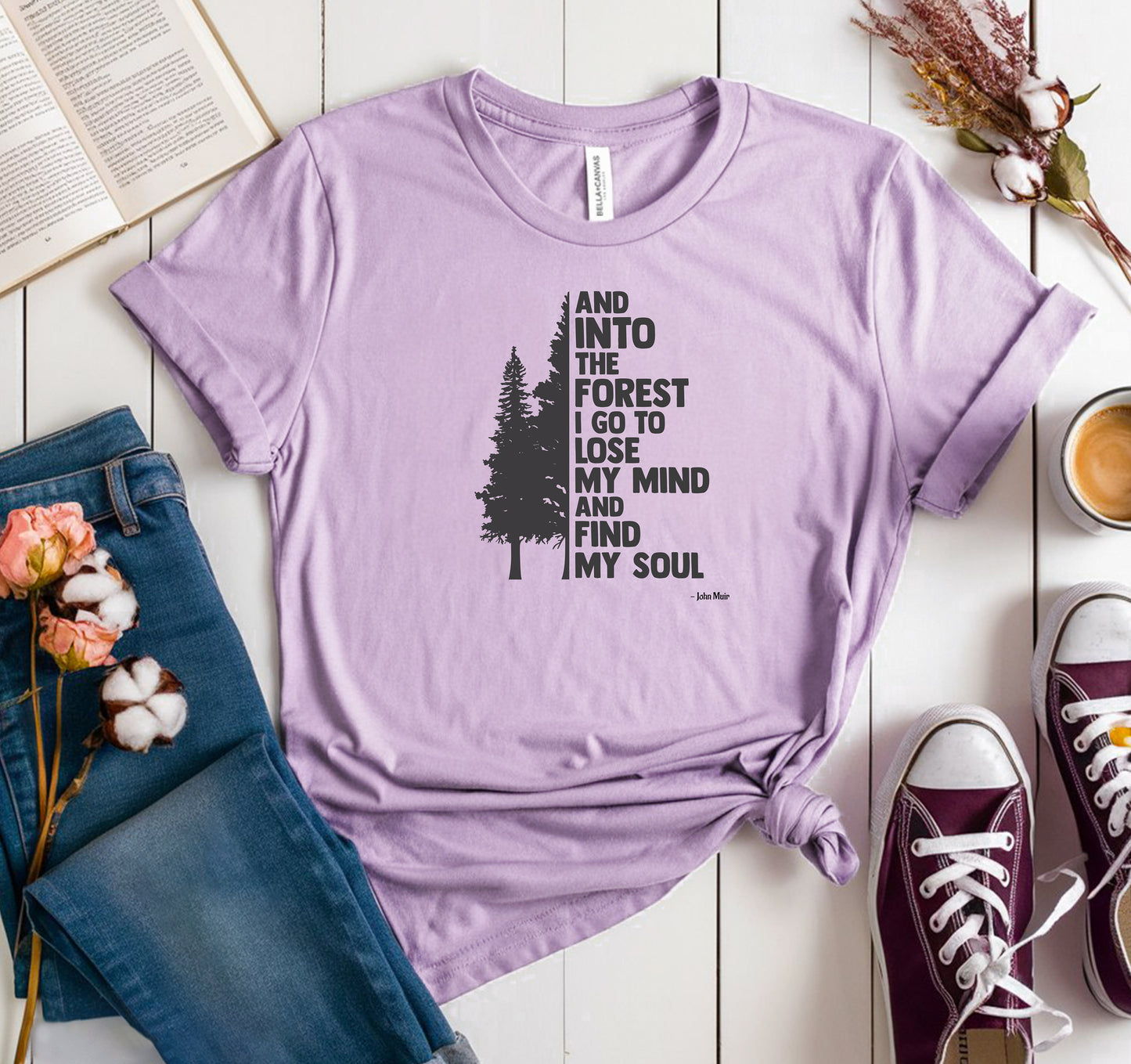 And Into The Forest I Go To Lose My Mind And Find My Soul T-shirt featuring a minimalist nature-inspired design with a tall pine tree alongside bold text of the famous John Muir quote. Printed on a soft lilac unisex tee, this design celebrates mindfulness, outdoor adventure, and the healing power of nature. Perfect for hikers, campers, and forest lovers who find peace and clarity in the wilderness.
