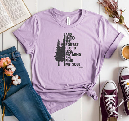 And Into The Forest I Go To Lose My Mind And Find My Soul T-shirt featuring a minimalist nature-inspired design with a tall pine tree alongside bold text of the famous John Muir quote. Printed on a soft lilac unisex tee, this design celebrates mindfulness, outdoor adventure, and the healing power of nature. Perfect for hikers, campers, and forest lovers who find peace and clarity in the wilderness.
