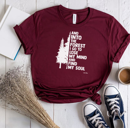 And Into The Forest I Go To Lose My Mind And Find My Soul T-shirt featuring a minimalist nature-inspired design with a tall pine tree alongside bold text of the famous John Muir quote. Printed on a soft maroon unisex tee, this design celebrates mindfulness, outdoor adventure, and the healing power of nature. Perfect for hikers, campers, and forest lovers who find peace and clarity in the wilderness.