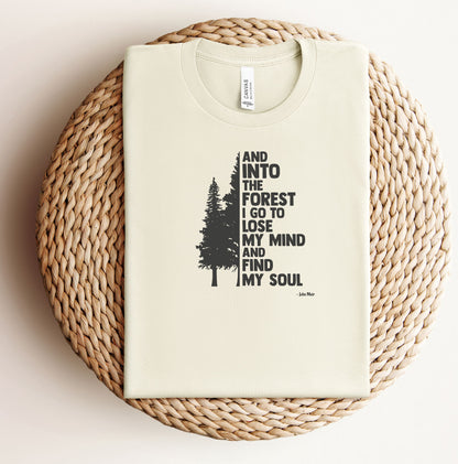 And Into The Forest I Go To Lose My Mind And Find My Soul T-shirt featuring a minimalist nature-inspired design with a tall pine tree alongside bold text of the famous John Muir quote. Printed on a soft natural unisex tee, this design celebrates mindfulness, outdoor adventure, and the healing power of nature. Perfect for hikers, campers, and forest lovers who find peace and clarity in the wilderness.