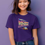Youth wearing a Team Purple t-shirt with a bold “Back to School” design featuring retro-style typography, a large pencil graphic above the text, and a yellow school bus driving below. A fun and colorful tee perfect for celebrating the new school year with energy and excitement.