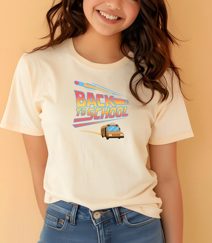 Youth wearing a Natural t-shirt with a bold “Back to School” design featuring retro-style typography, a large pencil graphic above the text, and a yellow school bus driving below. A fun and colorful tee perfect for celebrating the new school year with energy and excitement.