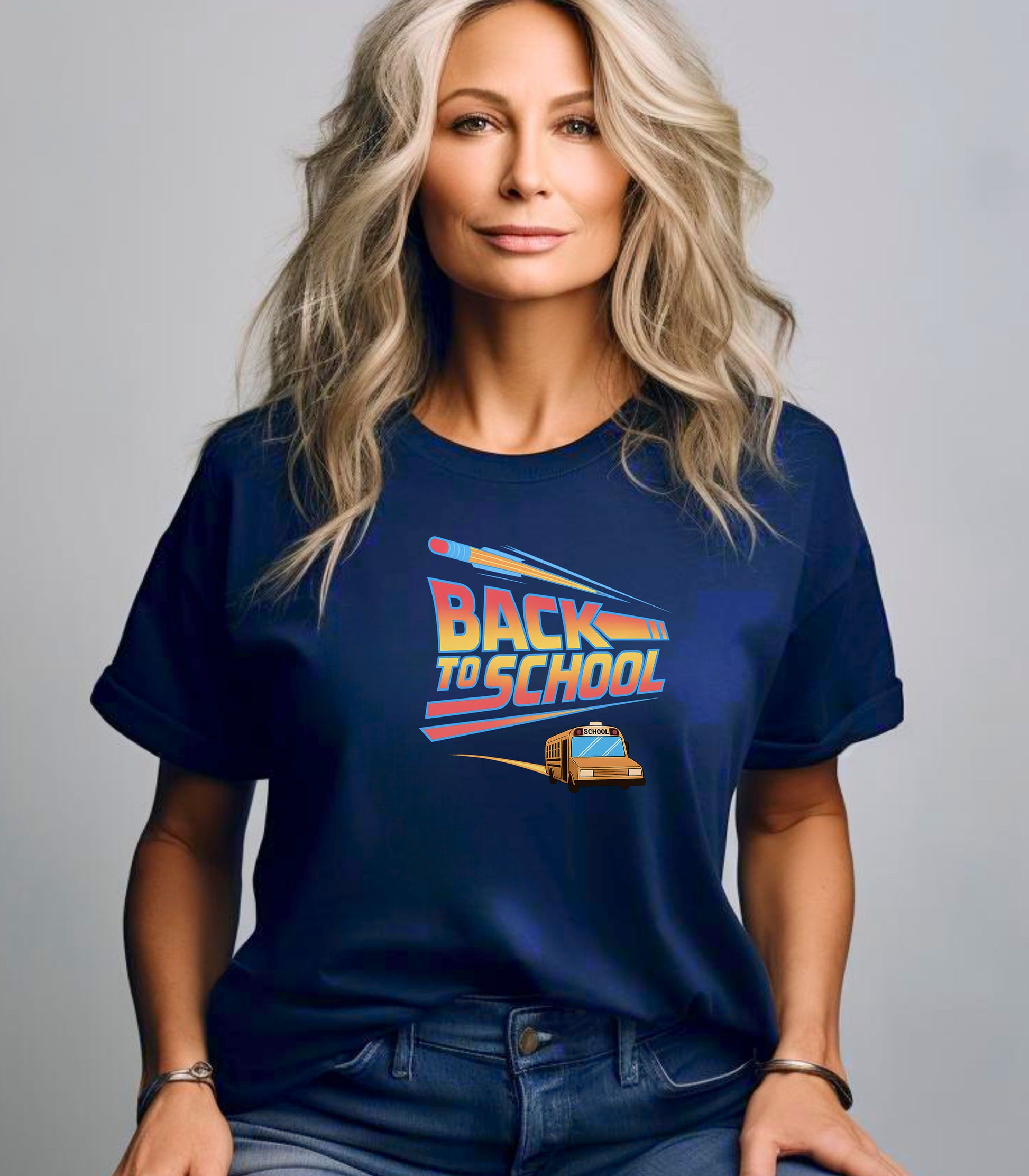 Person wearing a True Navy t-shirt with a bold “Back to School” design featuring retro-style typography, a large pencil graphic above the text, and a yellow school bus driving below. A fun and colorful tee perfect for celebrating the new school year with energy and excitement.