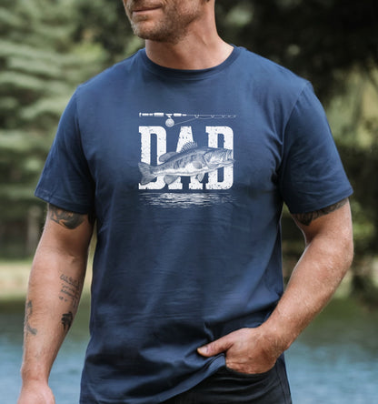 Bass Fishing Dad T-shirt featuring the word 'DAD' in bold, distressed white lettering with a detailed bass fish illustration overlaying the text. A fishing rod graphic runs above the design, with subtle water ripple details below. Printed on a denim unisex tee, this shirt is perfect for dads who love fishing, making it an ideal gift for Father’s Day, birthdays, or weekend fishing trips.