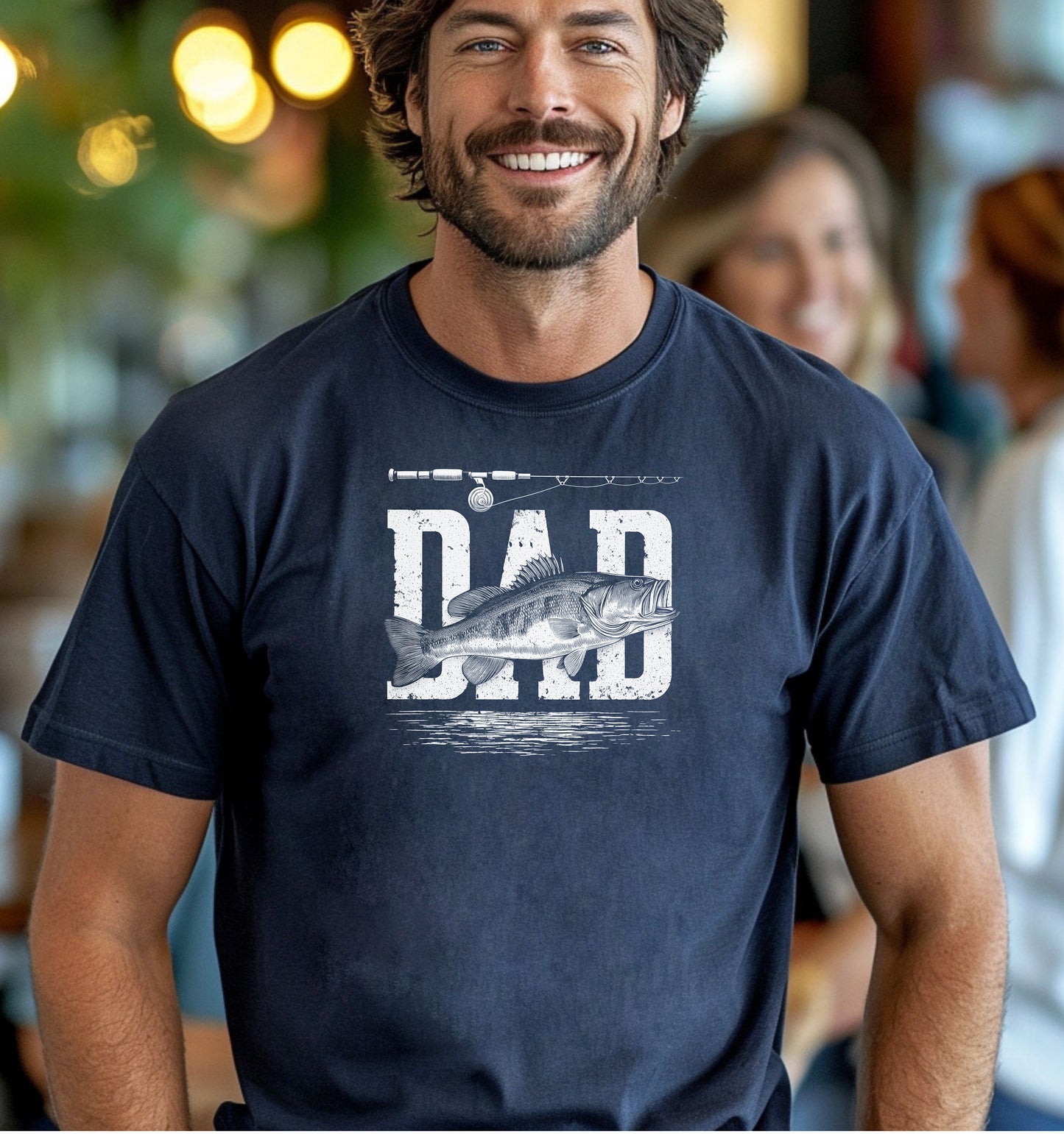 Bass Fishing Dad T-shirt featuring the word 'DAD' in bold, distressed white lettering with a detailed bass fish illustration overlaying the text. A fishing rod graphic runs above the design, with subtle water ripple details below. Printed on a midnight unisex tee, this shirt is perfect for dads who love fishing, making it an ideal gift for Father’s Day, birthdays, or weekend fishing trips.