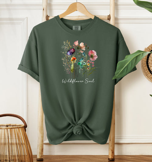 Wildflower Soul T-shirt featuring a soft watercolor-style bouquet of colorful wildflowers with delicate stems and leaves. Printed on a moss unisex Comfort Colors tee, this nature-inspired boho design is perfect for free spirits, gardeners, flower lovers, and those with a love for the outdoors and artistic floral fashion.
