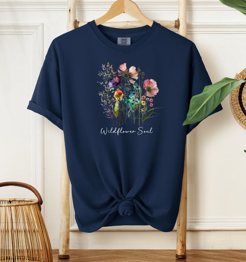 Wildflower Soul T-shirt featuring a soft watercolor-style bouquet of colorful wildflowers with delicate stems and leaves. Printed on a true navy unisex Comfort Colors tee, this nature-inspired boho design is perfect for free spirits, gardeners, flower lovers, and those with a love for the outdoors and artistic floral fashion.