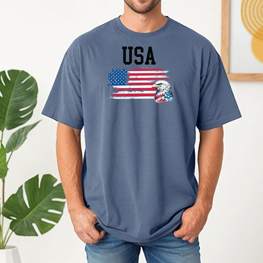 Blue Jean  t-shirt featuring a bold patriotic design with the word 'USA' above a distressed American flag and a fierce bald eagle head on the right side. A strong, classic graphic tee perfect for 4th of July, Memorial Day, Veterans Day, or everyday wear to show American pride and patriotism.
