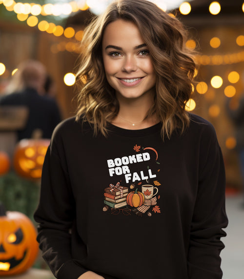 Black Gildan sweatshirt featuring a cozy autumn-themed “Booked For Fall” design with stacked books, pumpkin, coffee mug, scarf, glasses, and falling leaves in warm fall tones. Perfect for book lovers who embrace sweater weather, pumpkin spice, and cozy reading sessions during the autumn season.