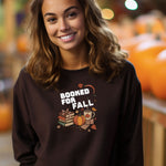 Dark Chocolate Gildan sweatshirt featuring a cozy autumn-themed “Booked For Fall” design with stacked books, pumpkin, coffee mug, scarf, glasses, and falling leaves in warm fall tones. Perfect for book lovers who embrace sweater weather, pumpkin spice, and cozy reading sessions during the autumn season.