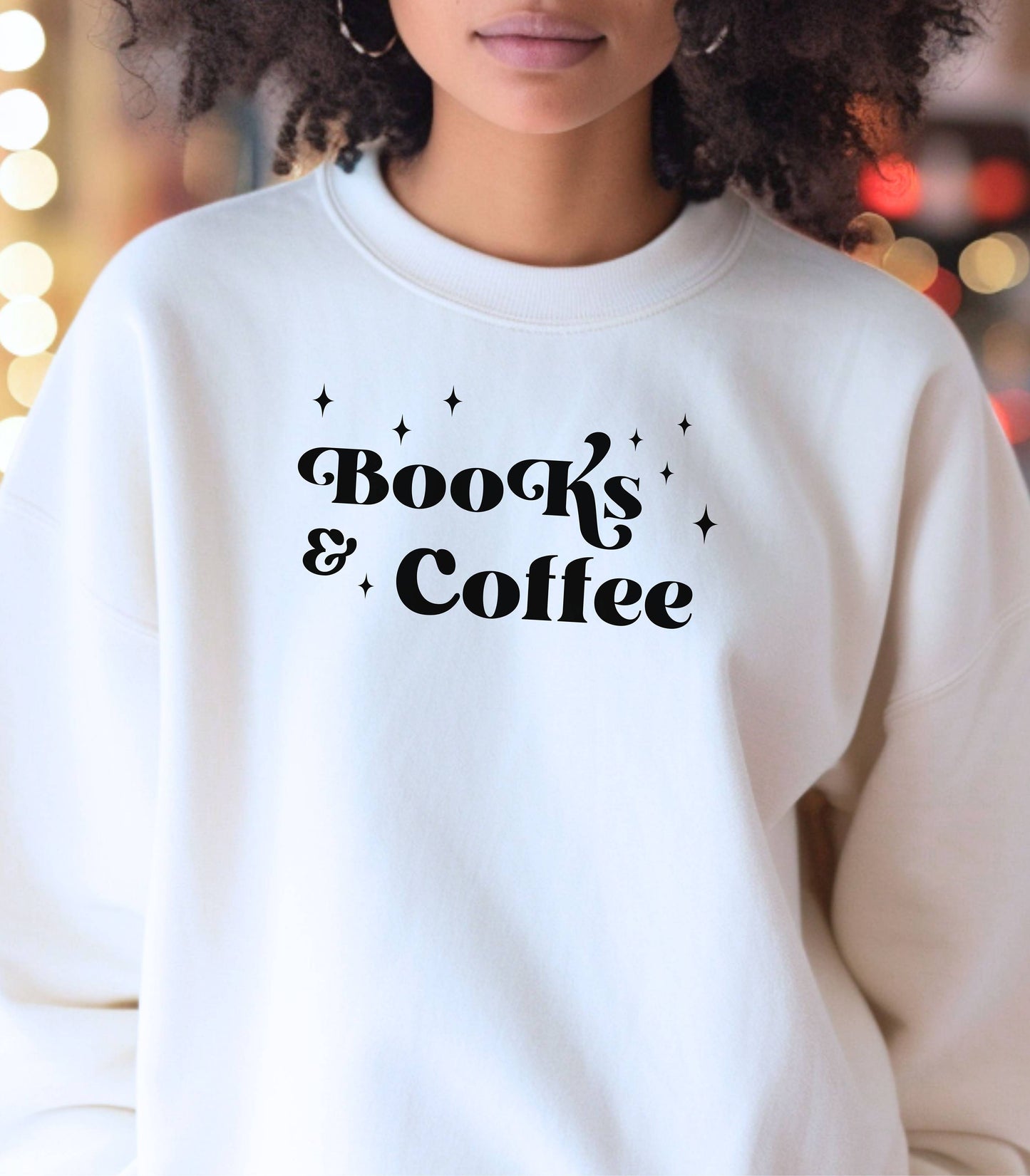 White Gildan sweatshirt featuring a stylish black “Books & Coffee” design in whimsical lettering, accented with small sparkle icons. A cozy and charming look for bookworms and coffee lovers who enjoy slow mornings, warm drinks, and quiet reading time. Perfect for relaxed, literary-inspired outfits.