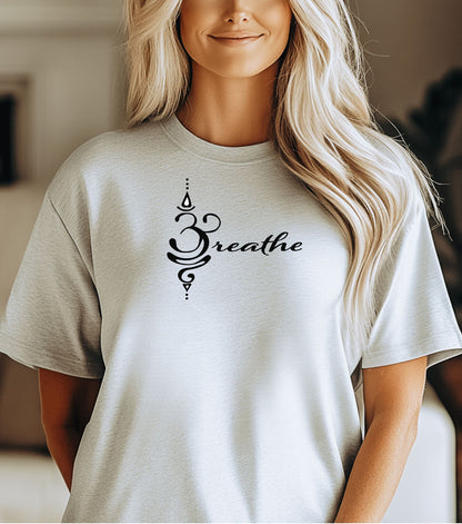 Breathe in Sanskrit T-shirt featuring an elegant black Sanskrit-inspired symbol integrated with the word 'Breathe' in flowing script. Printed on a soft, short-sleeve ash unisex tee, this calming design promotes mindfulness and relaxation. Perfect for yoga enthusiasts, meditation practitioners, and anyone embracing a peaceful, intentional lifestyle.