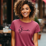 Breathe in Sanskrit T-shirt featuring an elegant black Sanskrit-inspired symbol integrated with the word 'Breathe' in flowing script. Printed on a soft, short-sleeve heather raspberry unisex tee, this calming design promotes mindfulness and relaxation. Perfect for yoga enthusiasts, meditation practitioners, and anyone embracing a peaceful, intentional lifestyle.