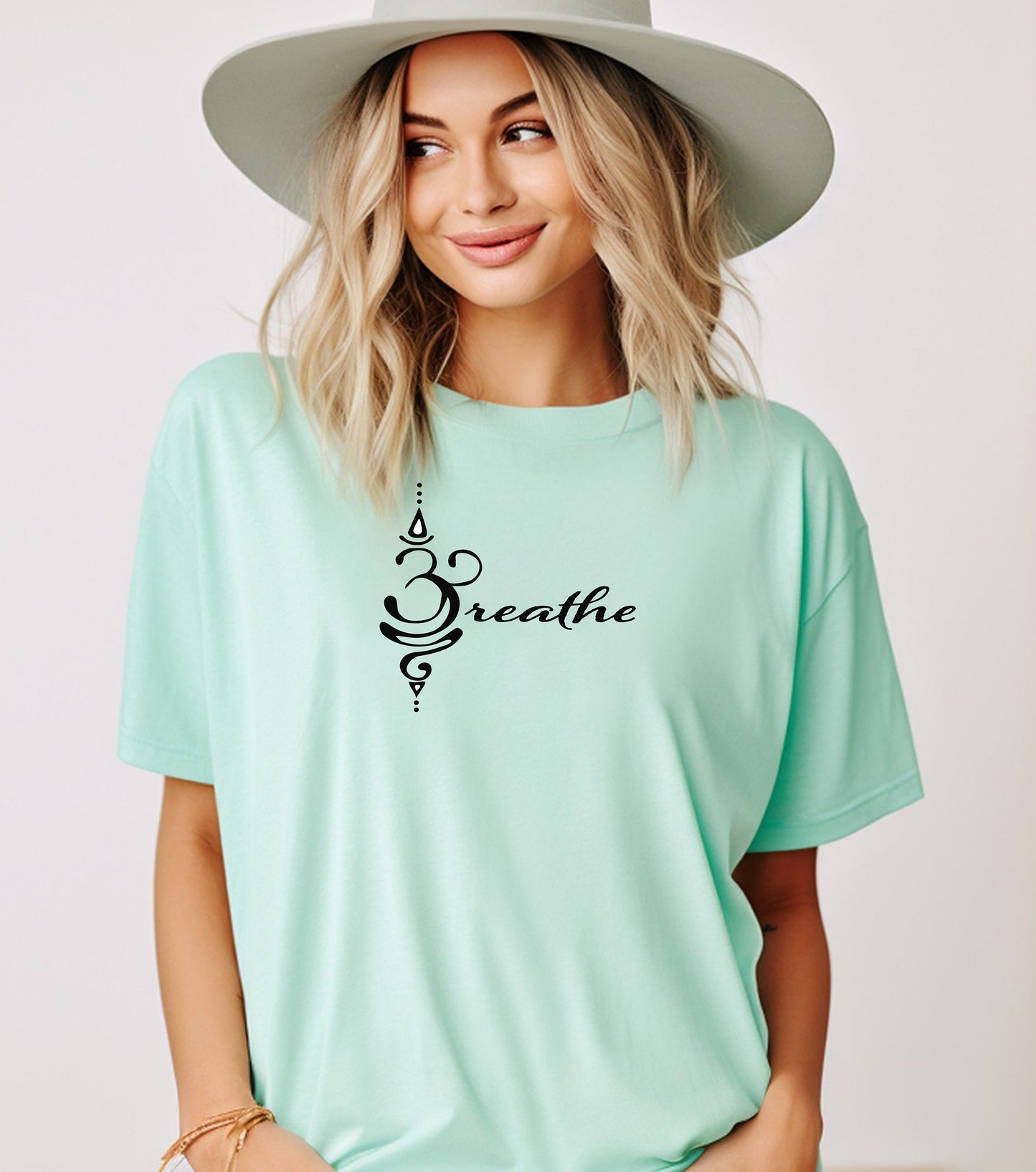 Breathe in Sanskrit T-shirt featuring an elegant black Sanskrit-inspired symbol integrated with the word 'Breathe' in flowing script. Printed on a soft, short-sleeve mint unisex tee, this calming design promotes mindfulness and relaxation. Perfect for yoga enthusiasts, meditation practitioners, and anyone embracing a peaceful, intentional lifestyle.