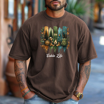 Person wearing an espresso T-shirt with a “Cabin Life” design featuring a colorful, watercolor-style vertical stripe background in earthy tones. The artwork includes pine trees, a log cabin, a campfire with boots, a lantern, and a backpack framed by autumn leaves. A rustic, outdoorsy design perfect for nature lovers, campers, and cabin getaways.