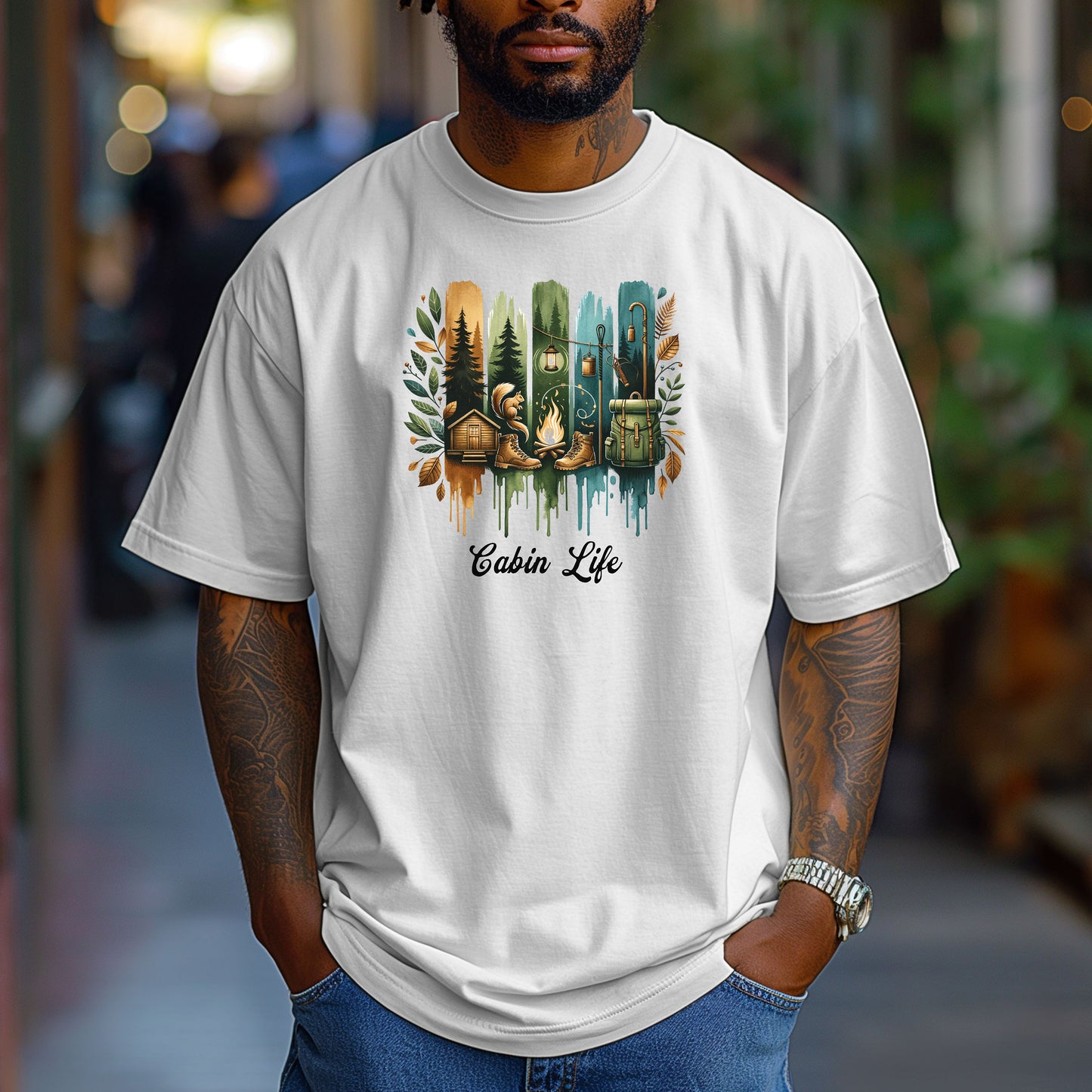 Person wearing a classic white T-shirt with a “Cabin Life” design featuring a colorful, watercolor-style vertical stripe background in earthy tones. The artwork includes pine trees, a log cabin, a campfire with boots, a lantern, and a backpack framed by autumn leaves. A rustic, outdoorsy design perfect for nature lovers, campers, and cabin getaways.