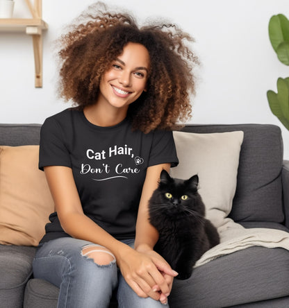 A person wearing a black T-shirt featuring the playful white text “Cat Hair, Don’t Care” with a paw print accent. The design captures a lighthearted message for cat lovers who embrace the joys and messiness of pet ownership, making it a fun, casual fashion choice.