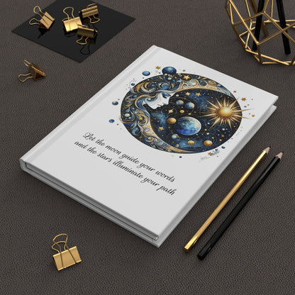 Hardcover journal with celestial design on a dark office surface with stationery items.