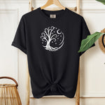 Celestial Tree of Life T-shirt featuring a white mystical tree design within a circular frame of stars, crescent moon, and swirling roots. Printed on a black unisex Comfort Colors tee, this nature-inspired celestial design is perfect for free spirits, stargazers, boho style lovers, and anyone drawn to cosmic, spiritual, or magical themes.