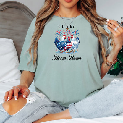 Bay light green t-shirt featuring a playful 'Chicka Boom Boom' design with three patriotic chickens, one decorated in red, white, and blue stars and stripes, and the other in white, surrounded by colorful fireworks. A third chicken is decorated in red and white stars on a blue body.  A fun and festive shirt perfect for 4th of July, barbecues, summer parties, and casual patriotic celebrations.