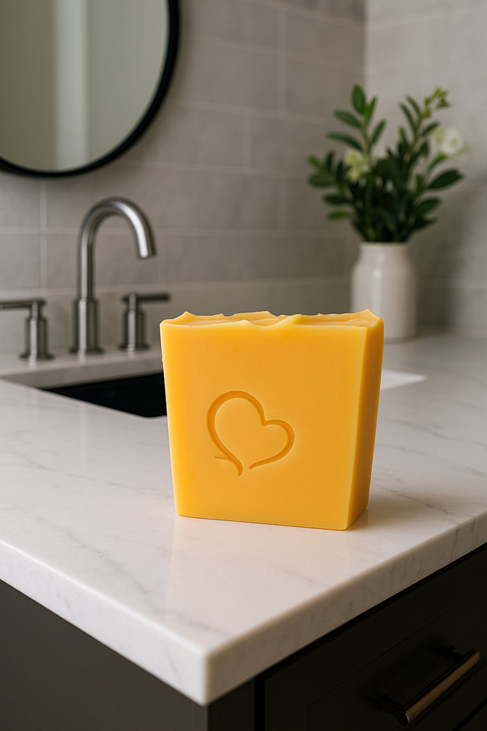 Citrus & Sage cold process soap with a heart imprint, handcrafted with an essential oil blend of orange, tangerine, lemon, pink grapefruit, sage, and cedarwood atlas. Vibrant golden-yellow bar, offering a refreshing, uplifting citrus aroma balanced with herbal and woody notes.