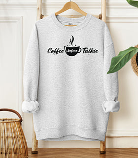 Ash Gildan sweatshirt with a centered black graphic of a steaming coffee cup and stylish text reading “Coffee before Talkie.” The playful design humorously declares the need for caffeine before conversation—perfect for coffee lovers who enjoy cozy comfort and a touch of sass in their morning routine.