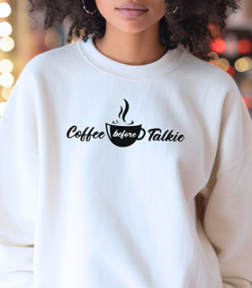 White Gildan sweatshirt with a centered black graphic of a steaming coffee cup and stylish text reading “Coffee before Talkie.” The playful design humorously declares the need for caffeine before conversation—perfect for coffee lovers who enjoy cozy comfort and a touch of sass in their morning routine.