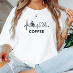 Graphic white t-shirt design featuring a heartbeat line that flows through a steaming coffee cup and forms a heart shape before it finishes. A creative and stylish illustration that shows coffee is essential to life—perfect for caffeine lovers, baristas, and anyone whose heart beats for coffee.