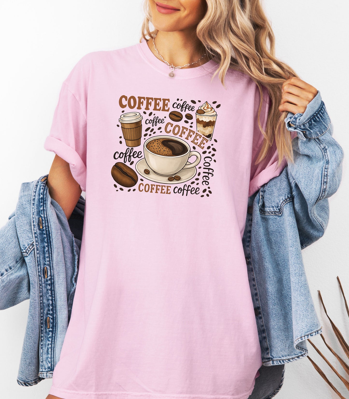 Blossom pink t-shirt featuring a playful coffee-themed design with multiple illustrated coffee cups, beans, and the word “coffee” repeated in various fonts and styles. Centered around a steaming cup of coffee on a saucer, this fun and cozy graphic is perfect for caffeine lovers who want to show off their coffee obsession in style.