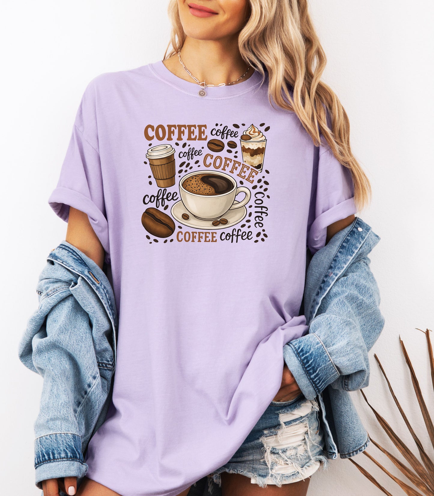 Orchid t-shirt featuring a playful coffee-themed design with multiple illustrated coffee cups, beans, and the word “coffee” repeated in various fonts and styles. Centered around a steaming cup of coffee on a saucer, this fun and cozy graphic is perfect for caffeine lovers who want to show off their coffee obsession in style.