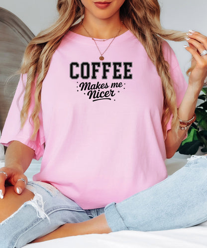 Graphic Blossom pink t-shirt design featuring bold varsity-style black text “COFFEE” with the phrase “makes me nicer” in a playful script underneath, surrounded by small stars. A fun and relatable design perfect for coffee lovers who know their mood improves with caffeine—ideal for casual wear with a humorous twist.