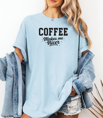 Graphic Chambray light blue t-shirt design featuring bold varsity-style black text “COFFEE” with the phrase “makes me nicer” in a playful script underneath, surrounded by small stars. A fun and relatable design perfect for coffee lovers who know their mood improves with caffeine—ideal for casual wear with a humorous twist.