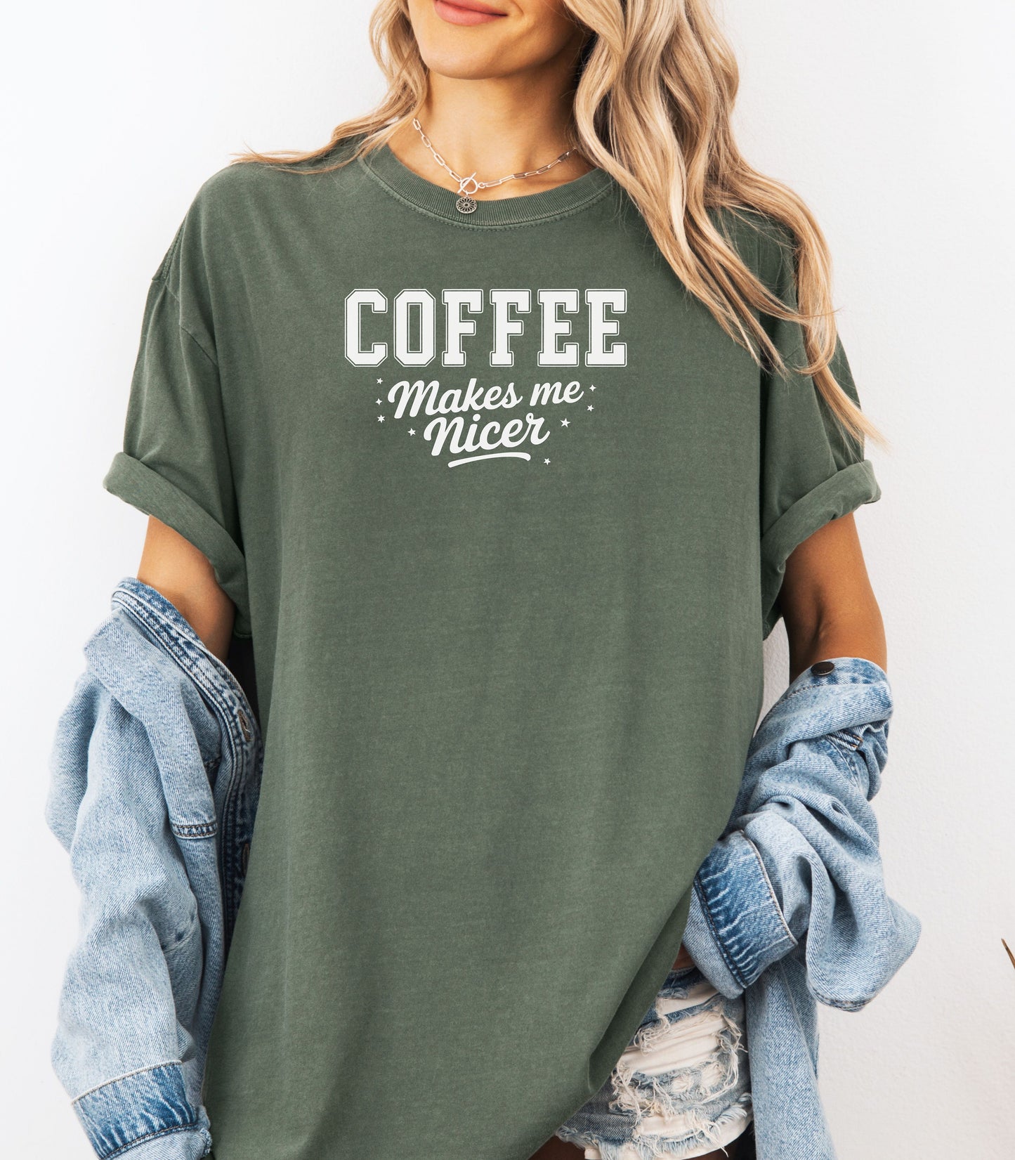 Graphic Hemp color t-shirt design featuring bold varsity-style white text “COFFEE” with the phrase “makes me nicer” in a playful script underneath, surrounded by small stars. A fun and relatable design perfect for coffee lovers who know their mood improves with caffeine—ideal for casual wear with a humorous twist.