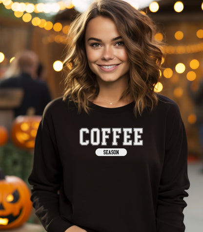 Black sweatshirt featuring a bold “COFFEE” design in varsity-style white lettering with the word “SEASON” underneath in a rounded black label. A cozy and stylish look perfect for coffee lovers embracing their favorite time of year—whether it’s fall, winter, or every season.