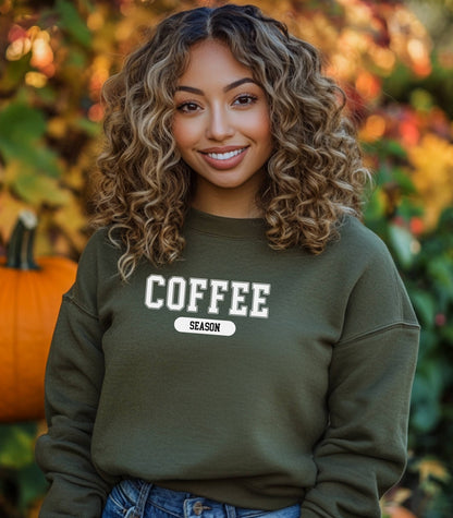Military Green sweatshirt featuring a bold “COFFEE” design in varsity-style white lettering with the word “SEASON” underneath in a rounded black label. A cozy and stylish look perfect for coffee lovers embracing their favorite time of year—whether it’s fall, winter, or every season.