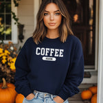 Cream sweatshirt featuring a bold “COFFEE” design in varsity-style white lettering with the word “SEASON” underneath in a rounded black label. A cozy and stylish look perfect for coffee lovers embracing their favorite time of year—whether it’s fall, winter, or every season.
