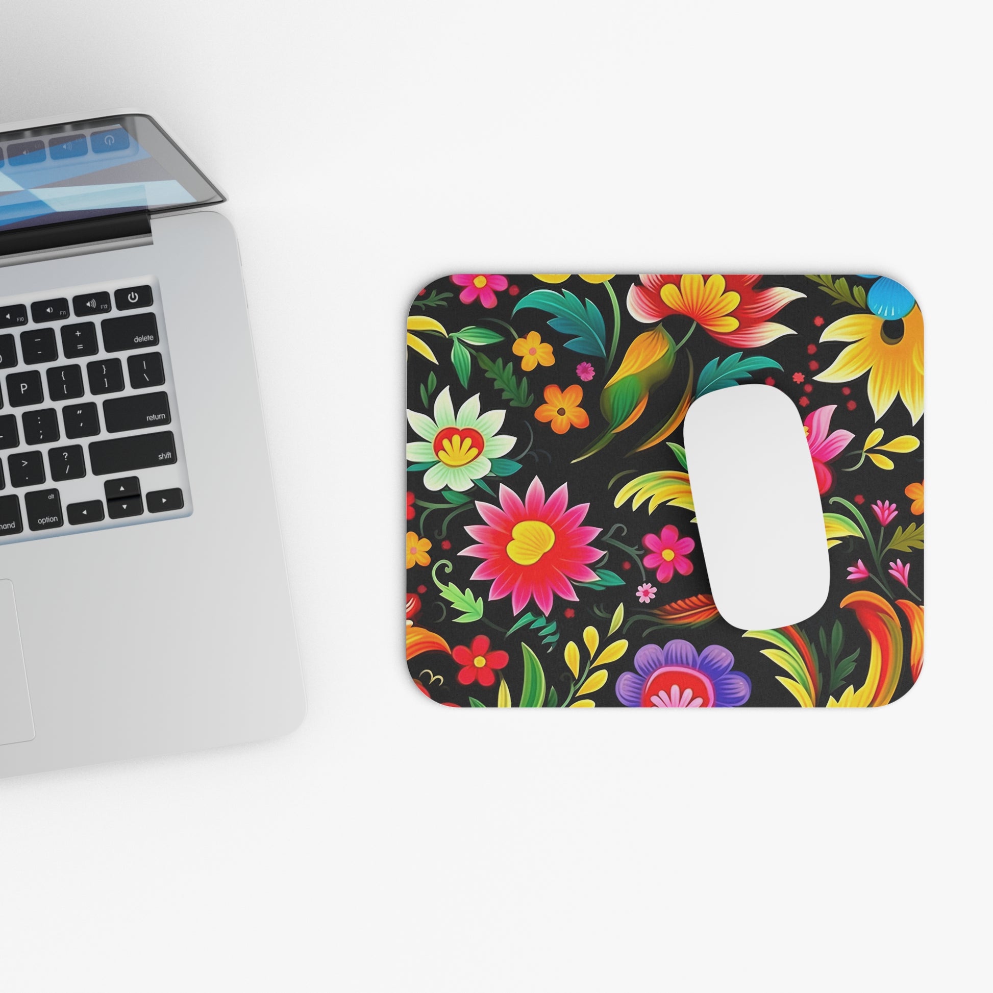 Floral Mexican pattern mouse pad next to a laptop on a white background