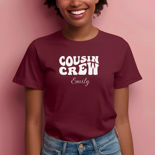 Smiling child wearing a Maroon youth T-shirt with bold white "Cousin Crew" text in a playful font and personalized with “Your Name” in elegant script below. The shirt is paired with jeans, creating a fun and youthful vibe perfect for family gatherings or matching cousin outfits.
