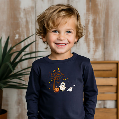 Adorable toddler wearing a navy long-sleeve T-shirt with a cute Halloween design featuring a spooky tree with falling leaves, a smiling jack-o'-lantern, and two ghost figures—one child ghost and one ghost dog. A playful and heartwarming fall design perfect for Halloween festivities and toddler apparel.